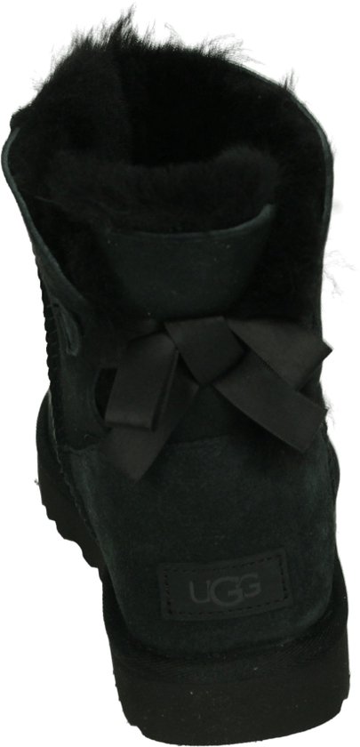 Achterkant van een zwarte UGG mini laars met strik en schapenvacht.