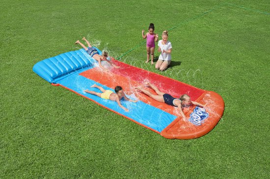 Vier kinderen en een volwassene bij een waterglijbaan; kinderen glijden met waterstralen.