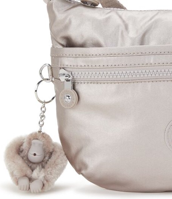 Sluiting met rits van een lichtgrijze Kipling tas met aan de rits een zacht, lichtgrijs aapje.