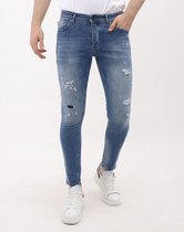 Blauwe slim fit jeans met ripped details, verfspatten en een leren merklabel.