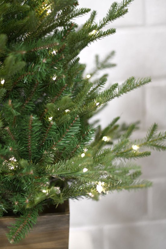 Groene Nordmann kunstkerstboom met 100 ingebouwde ledlampjes in een houten pot.