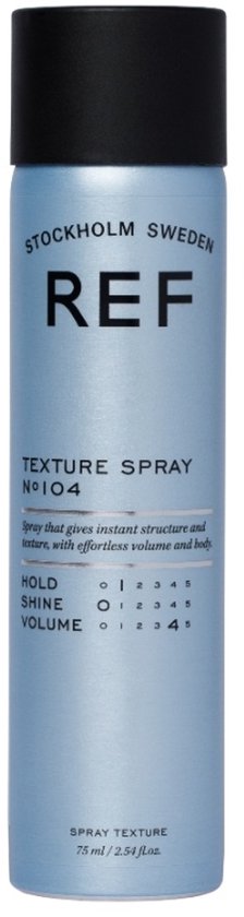 Blauwe sprayfles met zwarte dop, met de tekst 'REF STOCKHOLM SWEDEN TEXTURE SPRAY N°104'.