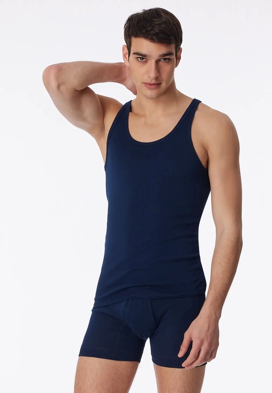 Model in een donkerblauwe Ten Cate singlet met ronde hals en bijpassende boxhort.