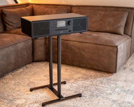 Zwarte Sonoro speakerstandaard met Sonoro Meisterstück Gen 2 unit erop, in woonkamer.