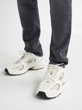 Witte lage sneakers van mesh en suède met beige accenten en een zwarte neus.