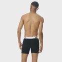 Model van achteren gezien, draagt een zwarte boxershort met witte adidas tailleband.