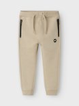 Beige joggingbroek met zwarte ritszakken en een trekkoord.