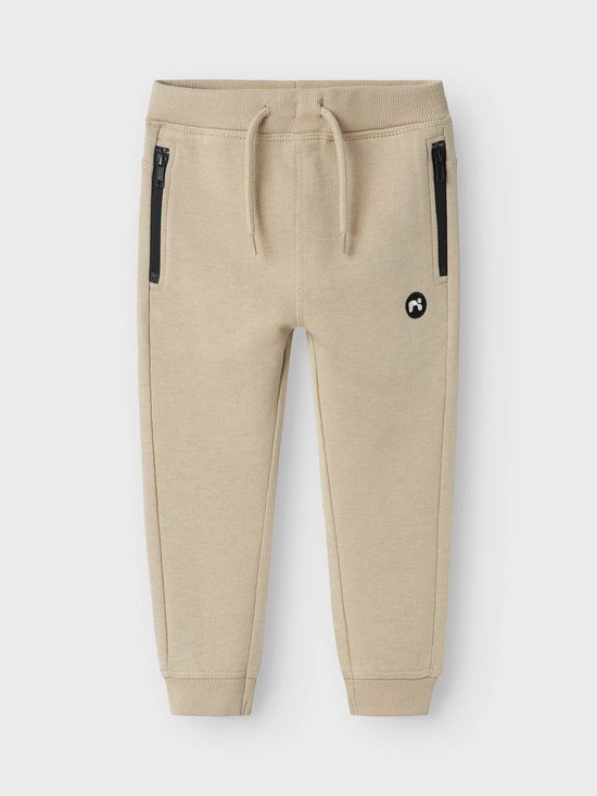 Beige joggingbroek met zwarte ritszakken en een trekkoord.