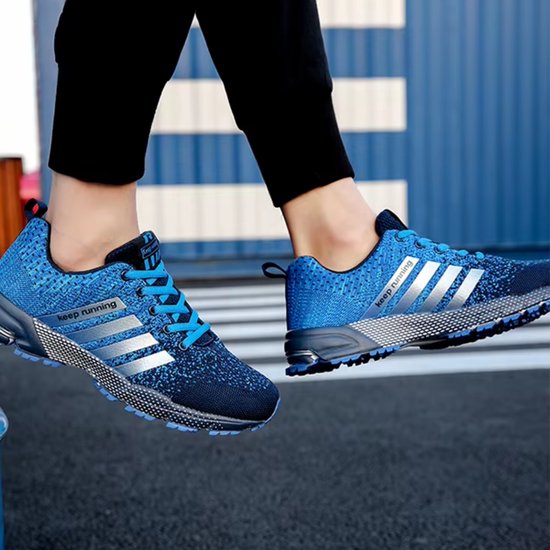 Blauwe hardloopschoenen met zilveren strepen en 'keep running' opdruk, gedragen door een persoon.