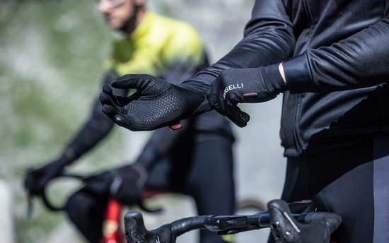 Fietser die Rogelli fietshandschoenen aantrekt, met stippenpatroon.