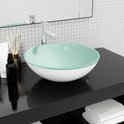 Lavabo ovale en verre blanc avec un bord vert menthe, posé sur un comptoir noir.