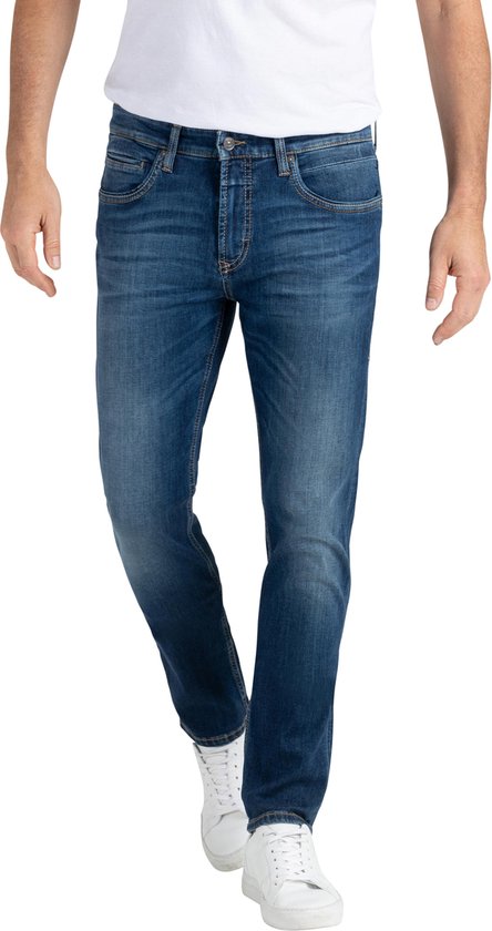 Man in een blauwe jeans met lichte wassing en witte sneakers.