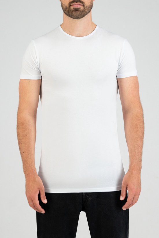 Man in een wit Slater t-shirt met ronde hals en korte mouwen, gedragen met een spijkerbroek.