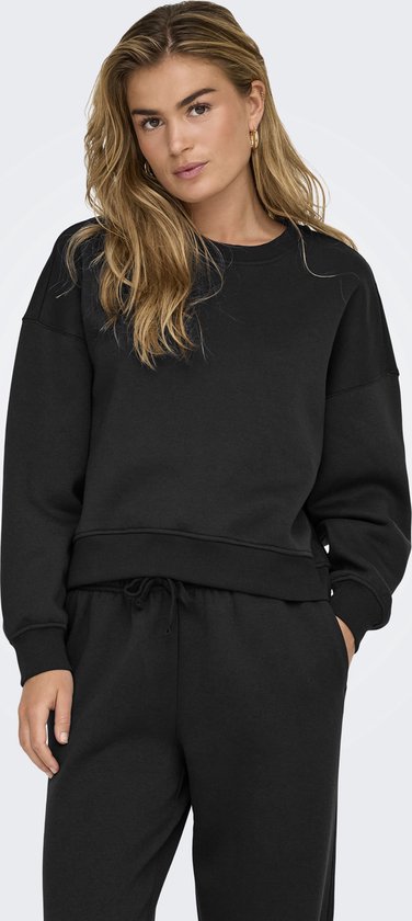 Model in zwarte longsleeve sweater met ronde hals en bijpassende joggingbroek.