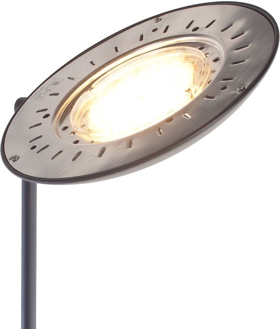 Gros plan d'un abat-jour chromé avec bord perforé, éclairé par une LED blanc chaud vif.