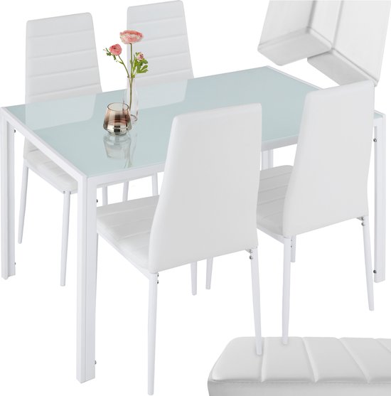 Witte eetkamerstoelen met horizontale stiksels en een glazen tafel, met bloemenvaasje en kaarshouder.