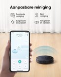 Hand houdt smartphone met eufy app, toont instellingen voor robotstofzuiger. Zwarte eufy robotstofzuiger op houten vloer.