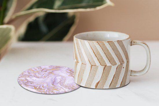 Sous-verre rond à motif marbre lilas et or, à côté d'une tasse.