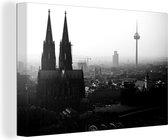 Canvas Schilderij De Dom van Keulen in Duitsland tijdens mist - zwart wit - 60x40 cm - Wanddecoratie
