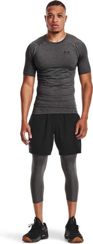 Man met donkergrijs, kort sportshirt met grijze panelen.