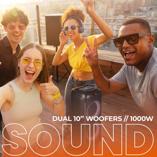 Grote zwarte Denver speaker met dubbele luidsprekers en veelkleurige LED-ringen, op een feestje op een dakterras.