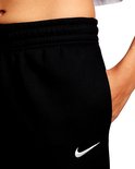 Close-up van de zak van een zwarte joggingbroek met wit Nike logo.