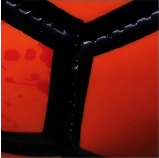 Detail van de naden van een oranje voetbal met zwarte vlakken.