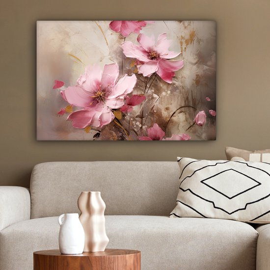 Canvas met roze bloemen, hangend boven een bank met sierkussens.