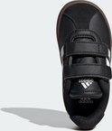 Bovenaanzicht van zwarte Adidas kindersneaker met witte strepen, klittenband en Adidas logo.