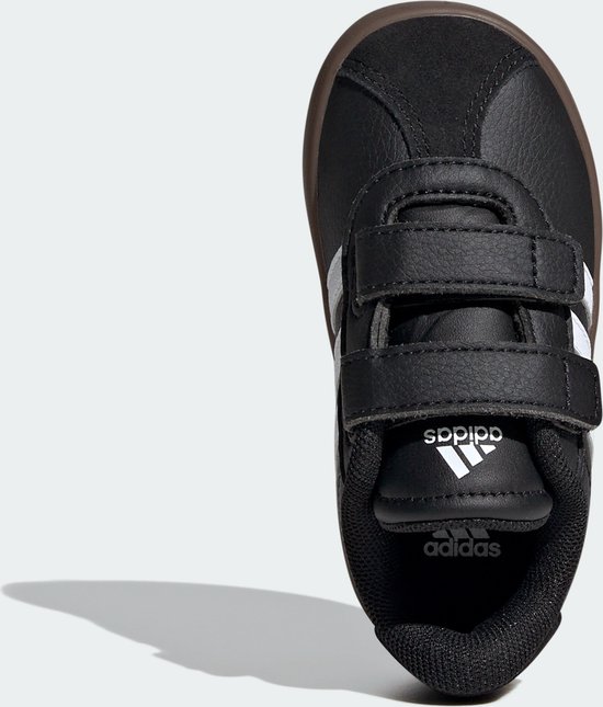 Bovenaanzicht van zwarte Adidas kindersneaker met witte strepen, klittenband en Adidas logo.