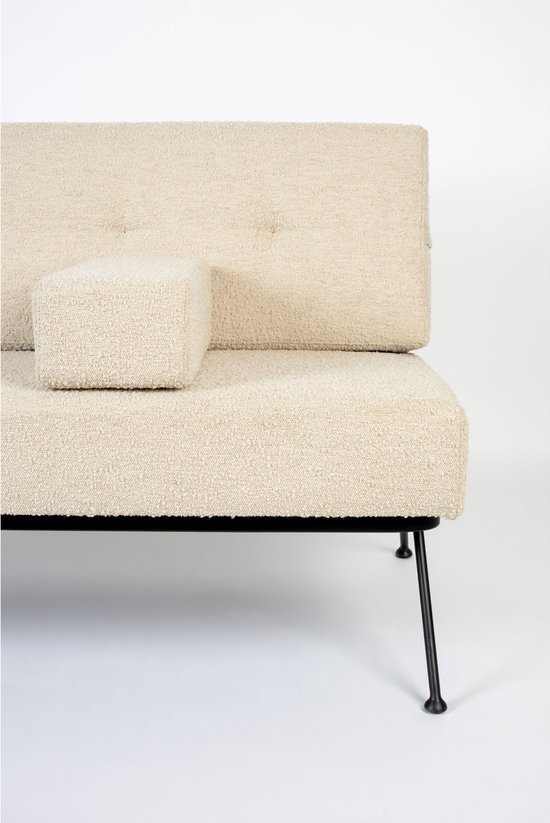 Zijkant van een beige bouclé bank met een los kussen, zwart metalen frame en poot.