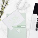 Een STABILO swing cool lichtgroene markeerstift op een notitieboek met de tekst 'SWING' erop.