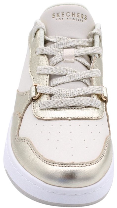 Vooraanzicht van een witte sneaker met champagnekleurige accenten en veters.