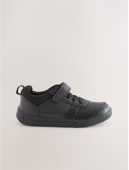 Zwarte sneaker met klittenbandsluiting en elastische veters, op een witte achtergrond.