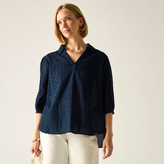 Donkerblauwe blouse met 3/4 mouwen, een open kraag en een cirkelpatroon, gedragen door een model.