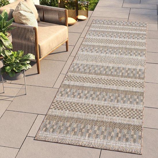 Tapis runner brun et beige à motif ethnique en rayures horizontales, posé sur une terrasse.