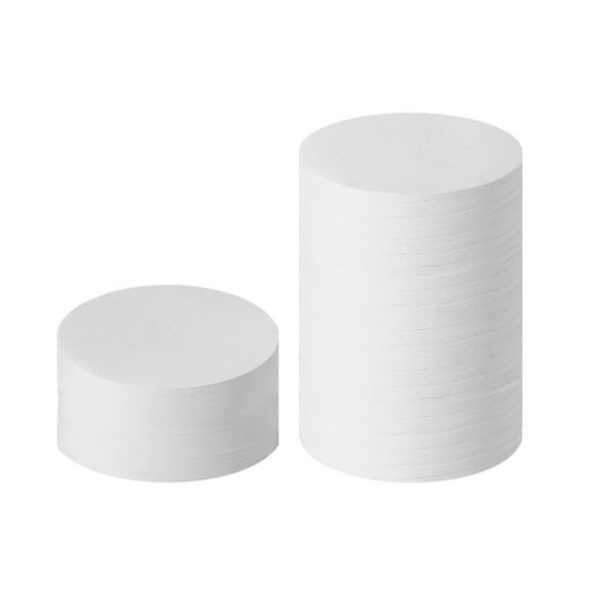 Twee stapels witte, ronde koffiefilters op een witte achtergrond.