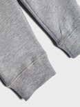 Detail van de geribbelde boorden van een grijze joggingbroek.