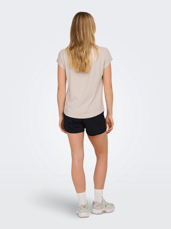 Model van achteren gezien in beige sportshirt met korte mouwen en zwarte short.
