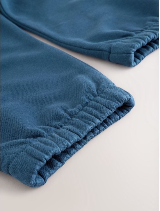 Detail van blauwe joggingbroek met elastische boorden.