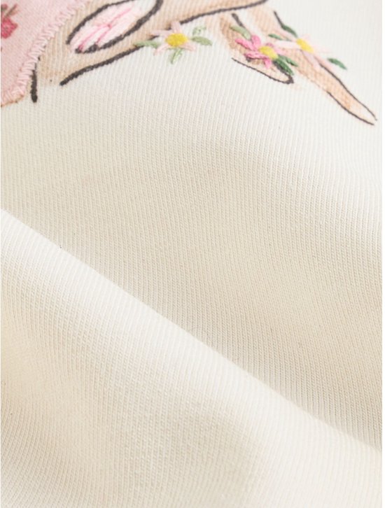 Close-up van de zoom van een roze legging met bloemenprint en ruches.