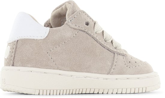 Lichtbruine suède sneaker met witte hiel en veters. Maat 18 zichtbaar op de zool.