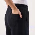 Detail van de achterzak van een zwarte joggingbroek met 'SEASIDE' label.