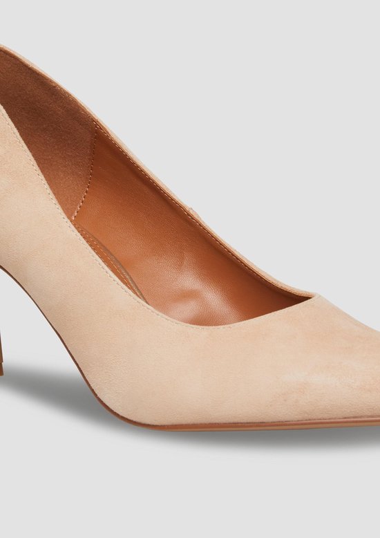 Close-up van de neus en zijkant van een lichtroze suède pump.