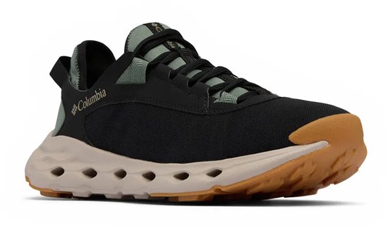 Chaussure de randonnée noire, semelle beige, accents vert pâle, lacets et logo Columbia.