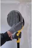 Handen met grijze handschoenen bevestigen een rond, gaasachtig schuurpad aan de gele schuurkop.