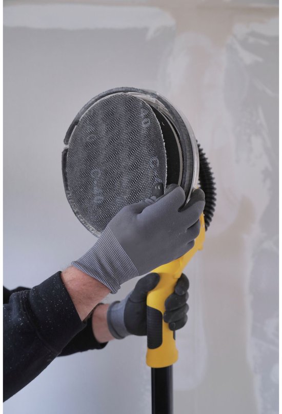 Handen met grijze handschoenen bevestigen een rond, gaasachtig schuurpad aan de gele schuurkop.