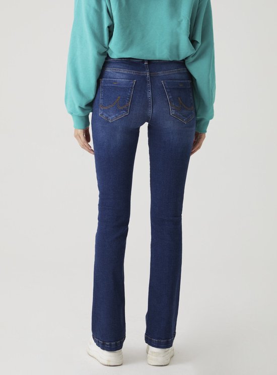 Achterkant van een model in een donkerblauwe flared jeans met een hoge taille en gebogen stiksels op de zakken.