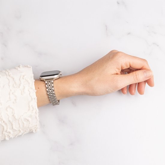 Een vrouw draagt een Apple Watch met een geborsteld gouden stalen bandje.
