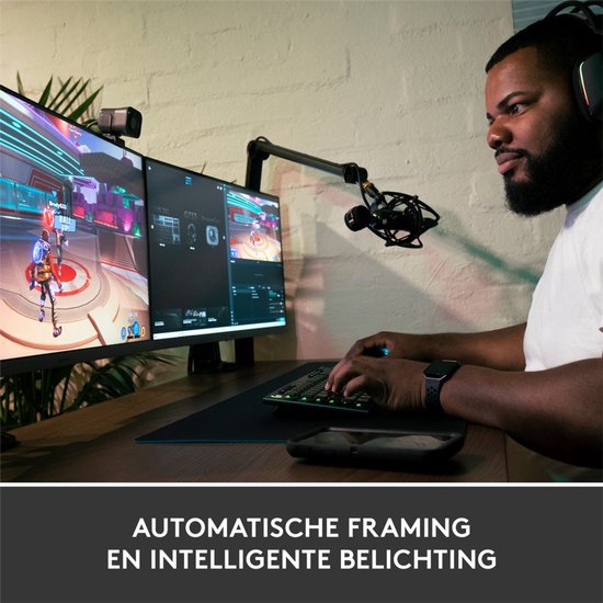 Homme avec un casque jouant à des jeux vidéo derrière deux écrans d'ordinateur, avec une webcam et un microphone.